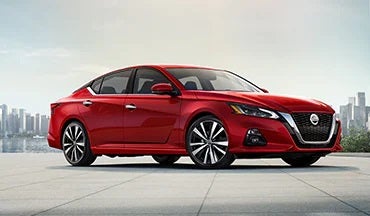 2023 Nissan Altima in red with city in background illustrating last year's 2022 model in Auffenberg Nissan in Shiloh IL